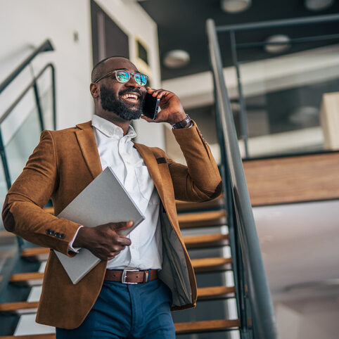 Professional man talking on phone walking up stairs