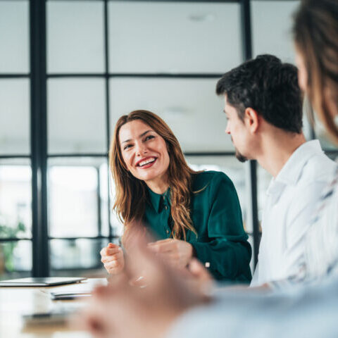Advisors and a client talking together around a conference table in a bright office